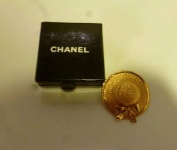 CHANEL Broche en métal doré en forme de chapeau de paille.
(non reproduit)