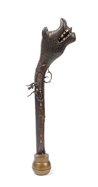 Style Qajar - XIXème siècle Pistolet. Crosse en bois sculpté à tête d'animal fantastique,...