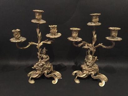 null Pair of bronze candelabra with three lights, depicting a Chinese dignitary holding...