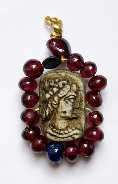null Cameo carved on both sides of busts, in light gray stone, surrounded by garnet...