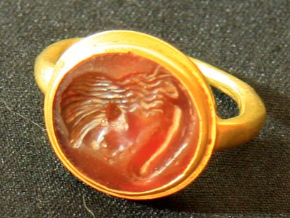 null Modern gold ring set with a carnelian intaglio engraved with a female head wearing...