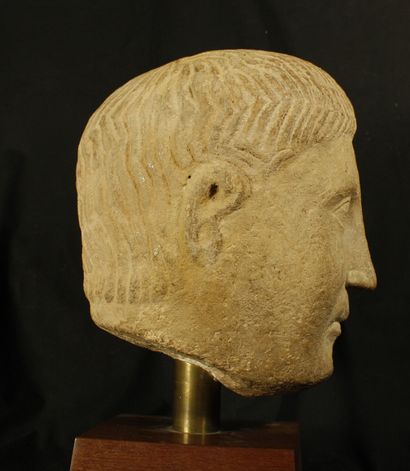 null Head of a man in epanelled limestone. His hair is done up in rows of large wavy...