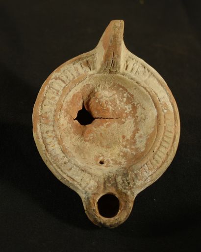 Red terracotta oil lamp with curved channel...