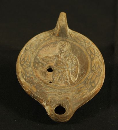 Terracotta oil lamp decorated with a knotted...