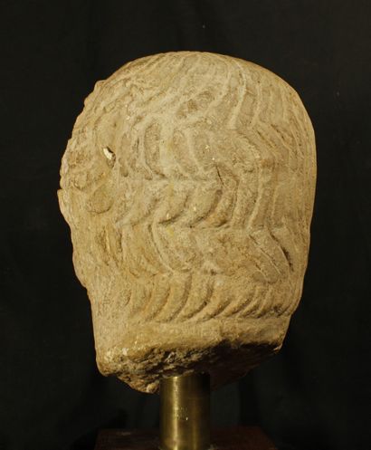 null Head of a man in epanelled limestone. His hair is done up in rows of large wavy...