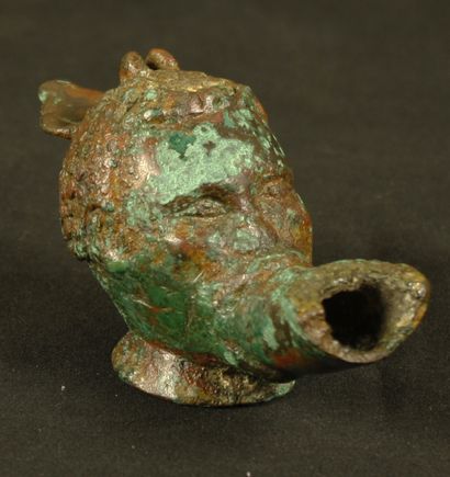 null Oil lamp in bronze with a bright red and green patina, in the shape of a Nubian...