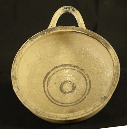 null Dish with a handle in terracotta with cream slip decorated with concentric circles...