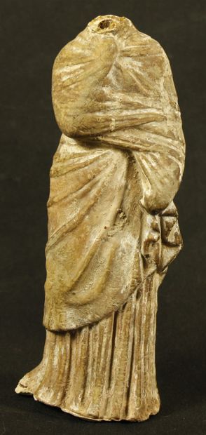 null Statuette of the acephalous Tanagra type in light-colored terracotta. She is...