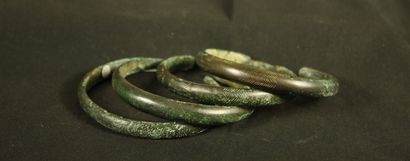 Set of 4 open bronze bracelets incised with...