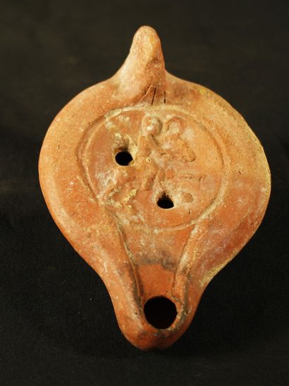 Oil lamp in red terracotta with curved channel....