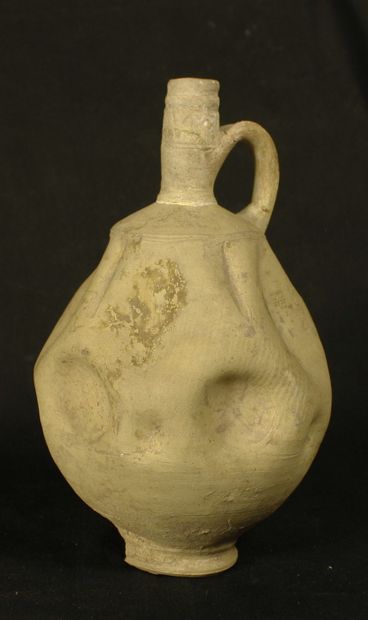 Terracotta jug with a series of depressions...