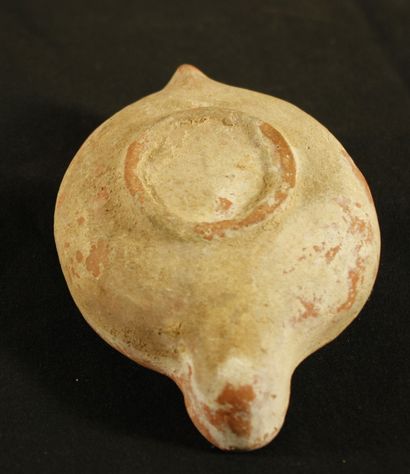 null Oil lamp in red clay with curved channel and full handle in the form of a spur...