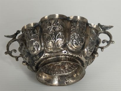 null Cup with two silver handles, bird-shaped grips, inside a bird holding in its...