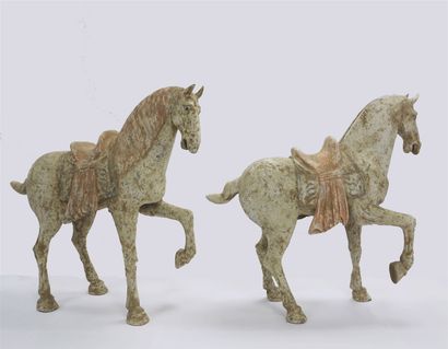  Pair of saddled horses with raised front leg of consequent size, 60cm high. 
The...