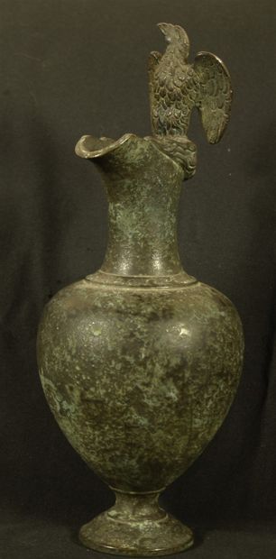 null Ewer in bronze with green patina decorated with an eagle on the lip. In the...