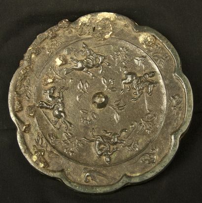 null Bronze mirror with scalloped edge. One side is polished and the other decorated...