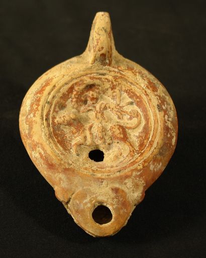 null Red terracotta oil lamp with heart-shaped spout decorated with Europa riding...