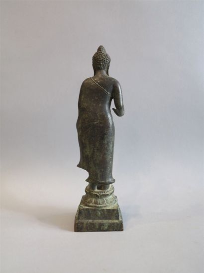 null Bouddha en bronze représenté debout sur un double socle lotiforme circulaire...