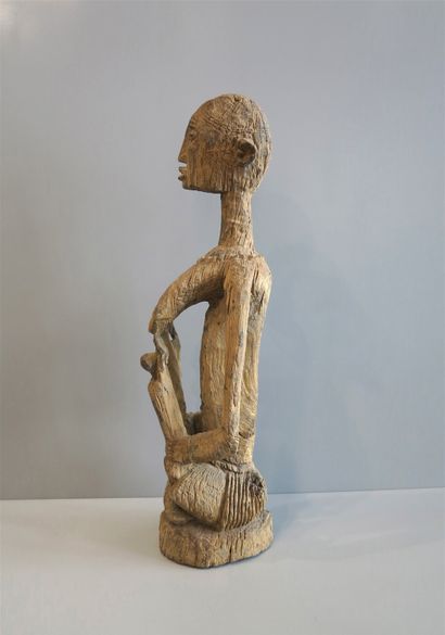 null Statuette en bois raviné représentant une maternité aux seins saillants auxquels...