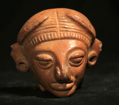 null Beige terracotta head with orange engobe adorned with earrings and a nariguera...