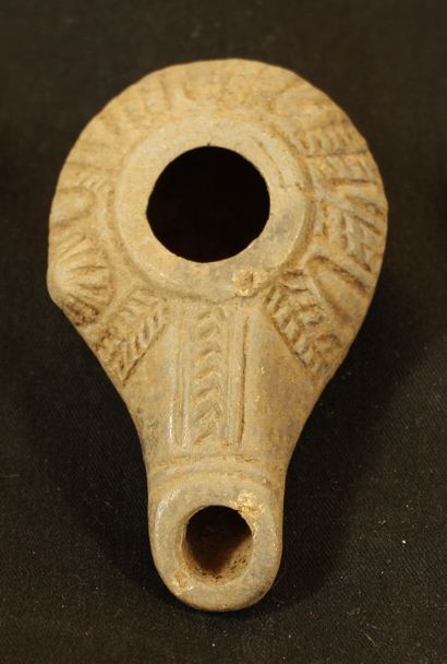 null Miniature terracotta oil lamp with an elongated tubular spout, a carinated tank,...