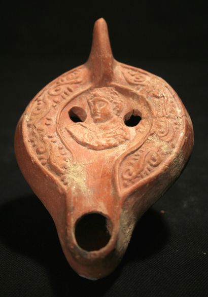 Oil lamp in red terracotta with curved channel...