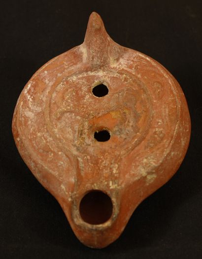 null Oil lamp in red terracotta with curved channel decorated with a deer. 
Roman...