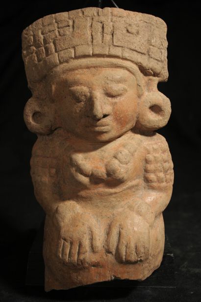 null Beige terracotta statuette with orange engobe representing a shaman seated cross-legged...
