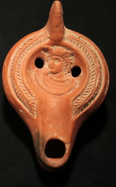 null Red terracotta oil lamp with curved channel decorated with the bust of Mercury...