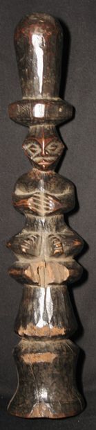 Drum stick carved with a seated figure 
End...