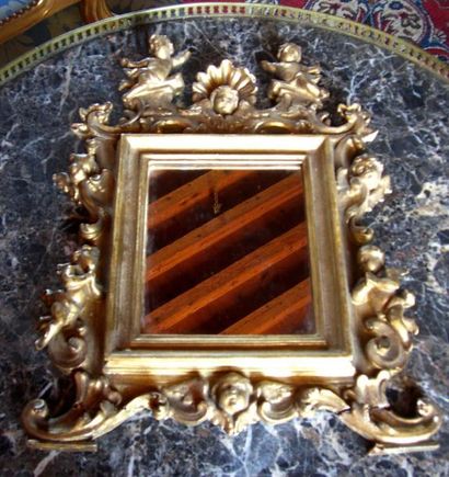 null Glace en bois doré et sculpté de coquilles et angelots. Italie, en partie XVIII°....