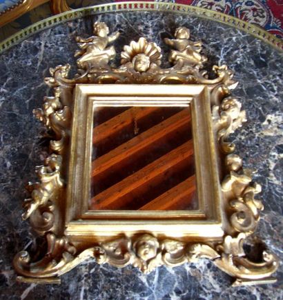 null Glace en bois doré et sculpté de coquilles et angelots. Italie, en partie XVIII°....