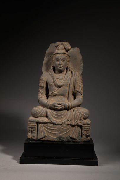 null Bhodhisatva auréolé assis un trône.Il porte le drapé utasaranga et tient ses...
