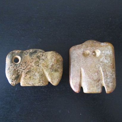 null Set of two amulets with nocturnal birds of prey. Nephrite jade partly calcified....