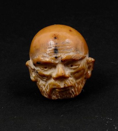 Wise man's head. Amber material. H: 3cm.