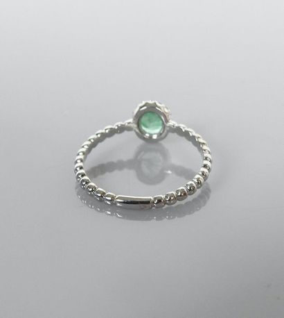 null Thin ring with a twisted body in white gold, 750 MM, centered by an oval emerald...