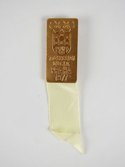 null Jeux Olympiques 1977. Prague 1977 - 79e session. 1 insigne (métal doré) ruban...