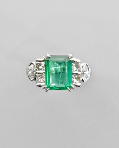 null White gold ring, 750 MM, set with a cut emerald weighing 2.50 carats and four...