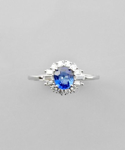 null White gold ring, 750 MM, centered on an oval sapphire weighing 0.71 carat surrounded...