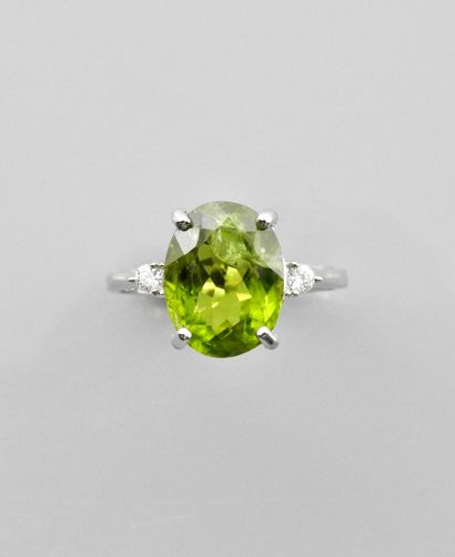 null White gold ring, 750 MM, set with an oval peridot weighing 5 carats, with two...