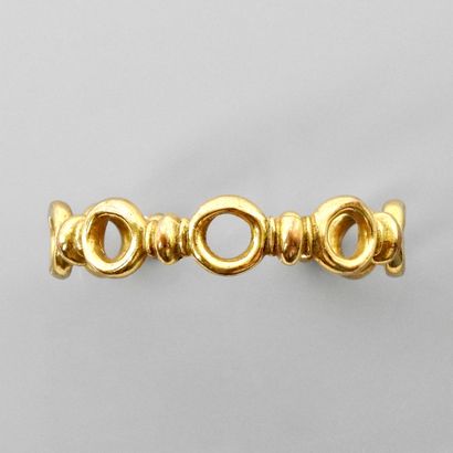 null 
Bracelet ouvert rigide en métal doré suite de motifs circulaires intercalés...