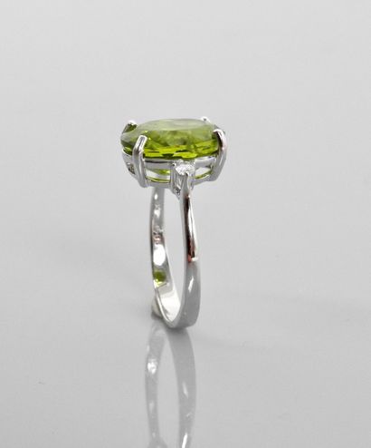 null White gold ring, 750 MM, set with an oval peridot weighing 5 carats, with two...