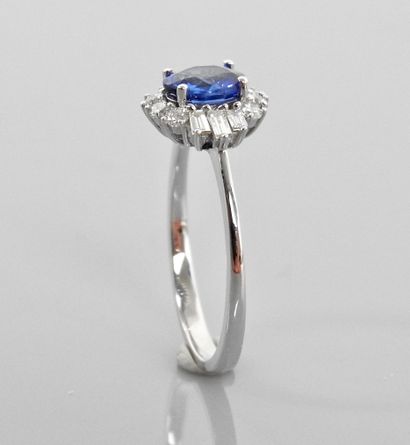 null White gold ring, 750 MM, centered on an oval sapphire weighing 0.71 carat surrounded...