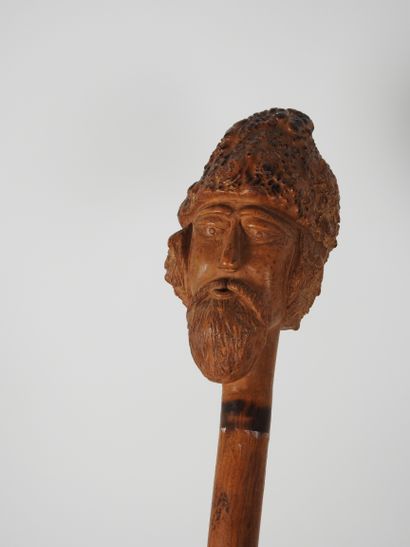 null Cane in one piece, the knob carved with a man's head wearing a cap 

Eastern...