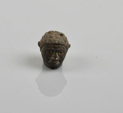 null Roman amulet head.

Black stone. 1,5cm