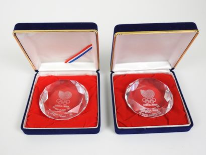 null Olympic Games. Two transparent glass round paperweights with spiral and rings...
