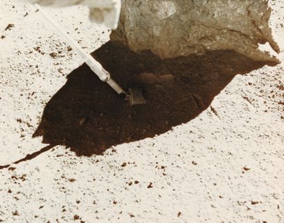 null NASA. Apollo 16. One of the mission's astronauts takes a sample of lunar rock...