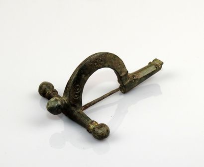  Grande fibule cruciforme à arc décoré d’ocelles, dite de légionnaire 
Bronze 7.7...