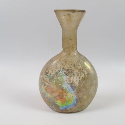 null Flat bottle with flared neck. Iridescent translucent glass. H13cm. Roman period....