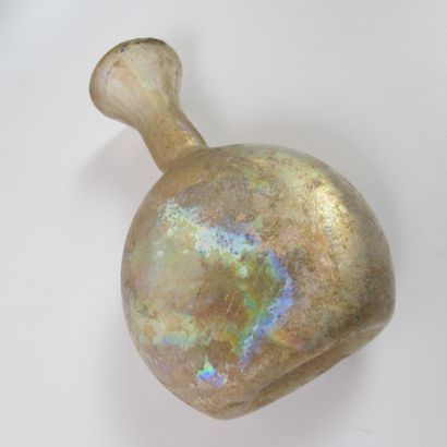 null Flat bottle with flared neck. Iridescent translucent glass. H13cm. Roman period....